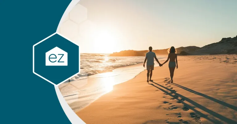 a couple walking in a white sand beach during sunset