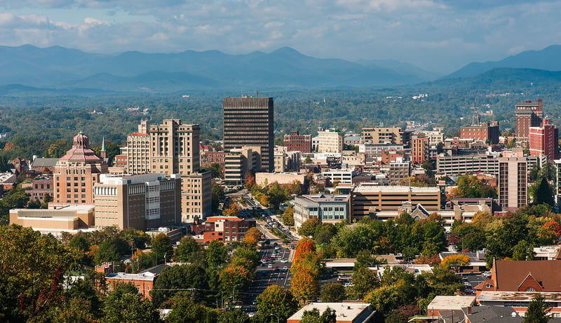 Tall buildings in downtown Asheville, North Carolina with mountains